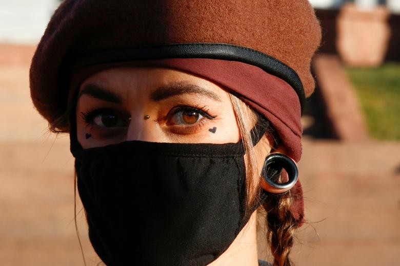Madison Martinez is seen with tattoos of black hearts near her eyes during a rally calling for justice for Elijah McClain after Governor Jared Polis amended his executive order regarding the investigation of McClain's death, which has raised concerns that charges against the police officers involved may ultimately be watered down in Denver, Colorado, November 21. REUTERS/Kevin Mohatt